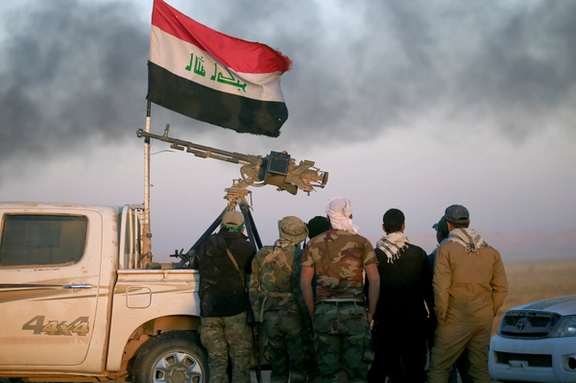 Shi'ite fighters look at smoke rising from clashes during a battle with Islamic State militants at the airport of Tal Afar west of Mosul, Iraq November 18, 2016.