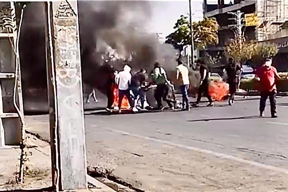 Young protesters setting up a barrier in a street in Karaj, near Tehran on October 12, 2022