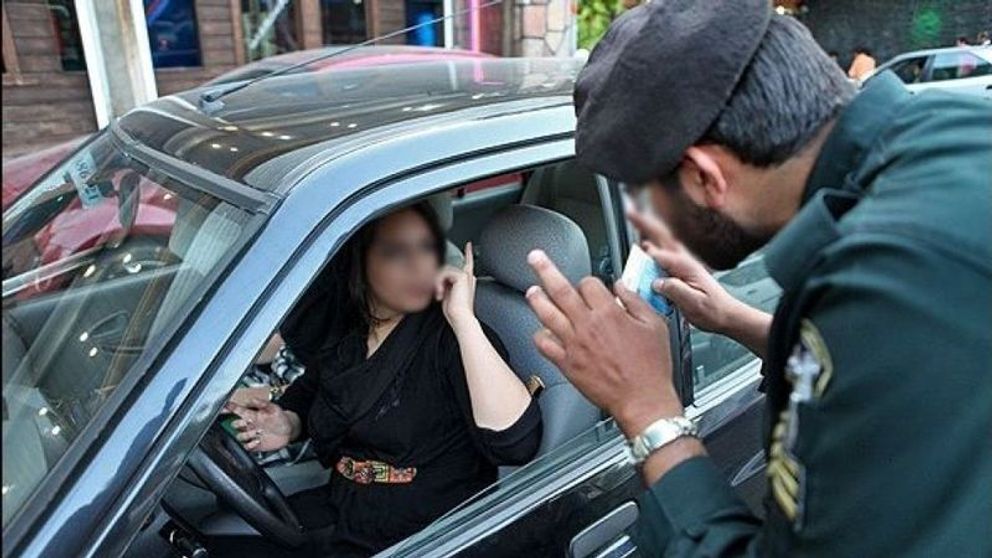 A policeman in Iran warnning a woman driver over her hijab