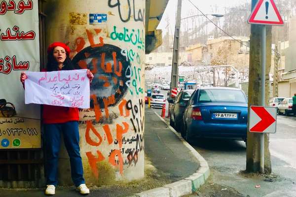 سجينة سياسية إيرانية ترفع لافتة "لا للإعدام" أمام سجن إيفين.. بعد إطلاق سراحها