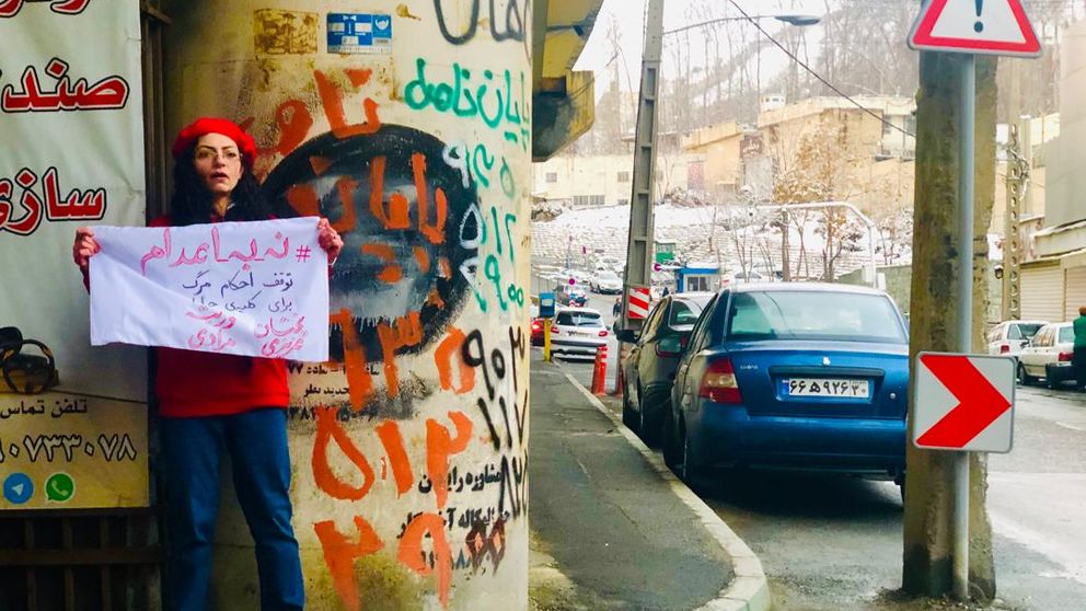 مریم یحیوی پس از آزادی پارچهنوشته «نه به اعدام» را مقابل زندان اوین در دست گرفت