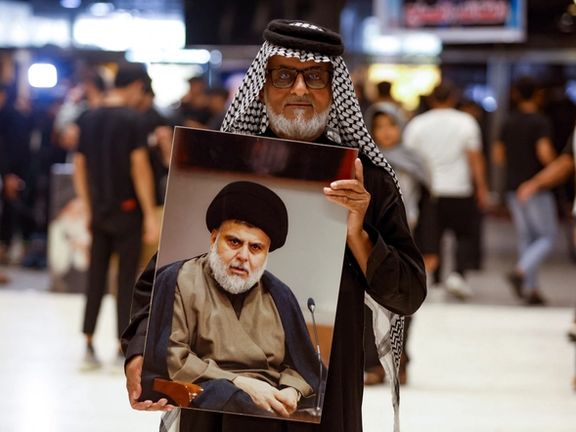 An Iraqi protester carrying a portrait of influential Shiite cleric Moqtada Sadr