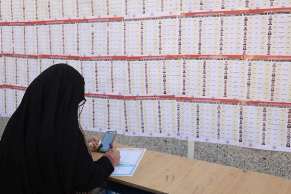 An Iranian woman checks the names of candidates during parliamentary elections at a polling station in Tehran, Iran, March 1, 2024.