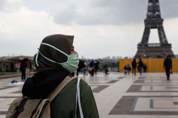 A woman, wearing a hijab and a protective face mask, walks at Trocadero square near the Eiffel Tower in Paris, France, May 2, 2021.