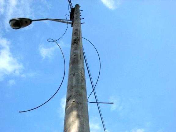 Electricity cables hanging from poles after people cut the resalable wires.