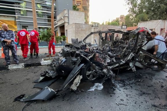 Members of the Syrian Arab Red Crescent stand near the wreckage of car after what the Syrian state television said was a "guided missile attack" on the car in the Mazzeh area of Damascus, Syria October 21, 2024.