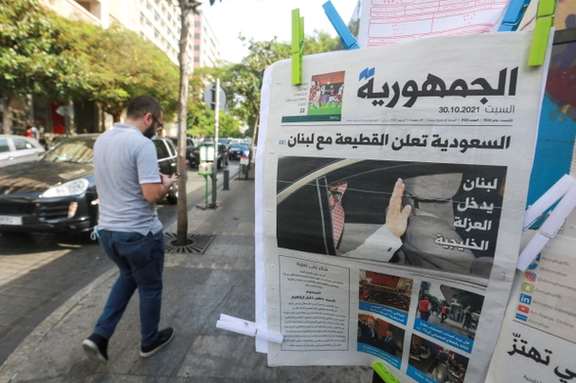 A man walks near a newspaper with a headline that reads " Saudi Arabia announces a boycott with Lebanon" in Beirut, October 30, 2021.