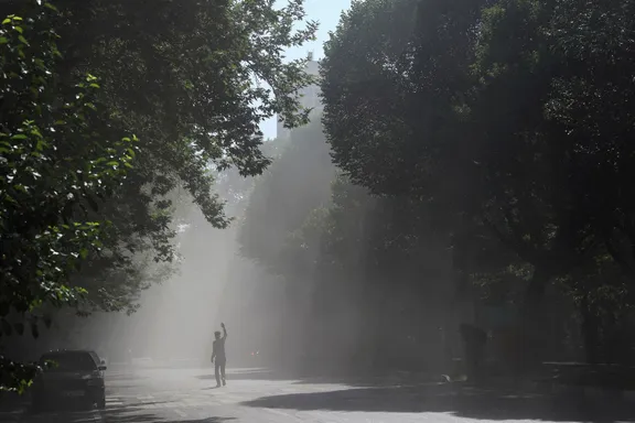 A man walks through the smoke of an explosion following the Israeli strikes on Iran, in the centre of Tehran, Iran, June 15, 2025.
