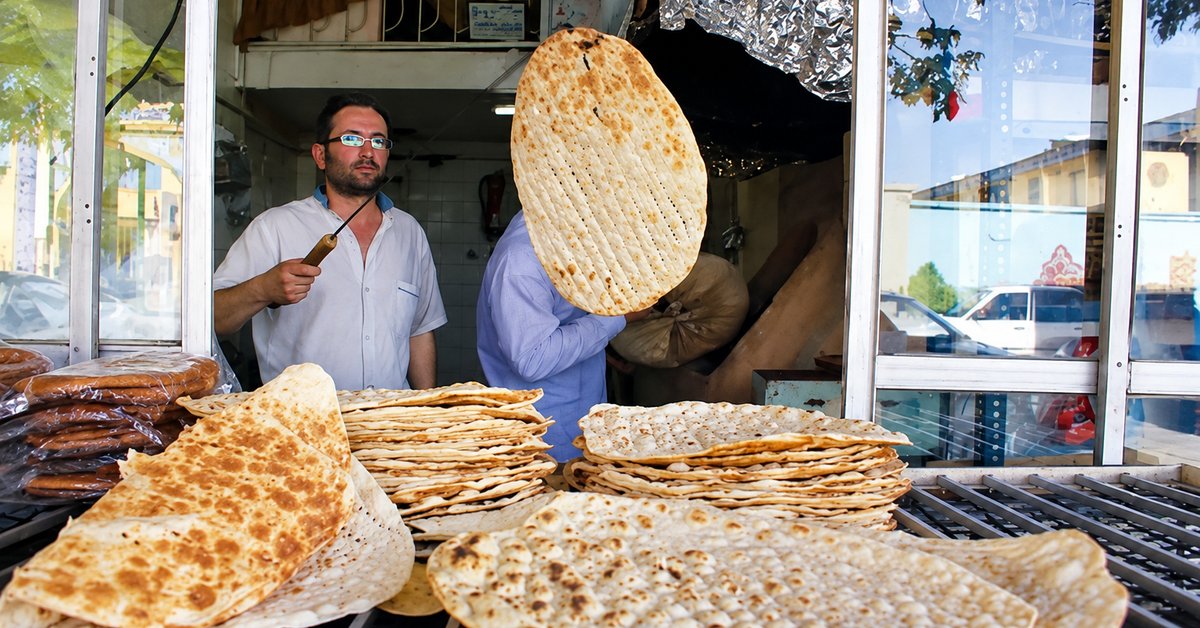 Iranians buy bread on credit, queue for chicken scraps