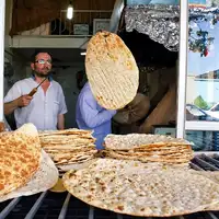 Iranians buy bread on credit, queue for chicken scraps