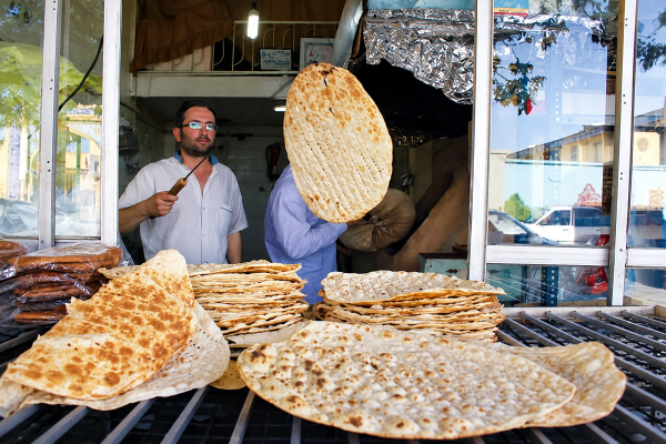 Iranians buy bread on credit, queue for chicken scraps