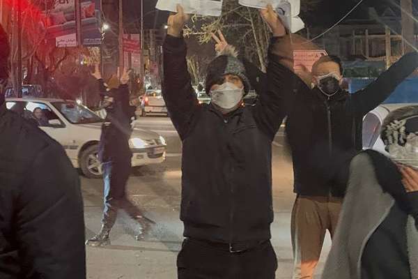 شهروند معترض با دستنوشتهای از ترامپ مقابل جمهوری اسلامی کمک خواست