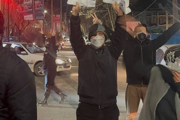 شهروند معترض با دستنوشتهای از ترامپ مقابل جمهوری اسلامی کمک خواست