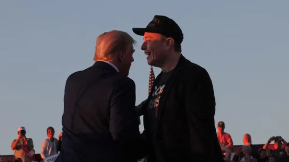 Tesla CEO and X owner Elon Musk stands with Republican presidential nominee former US president Donald Trump during a campaign rally, on the day Trump returns to the site of the July assassination attempt against him, in Butler, Pennsylvania, US, October 5, 2024.