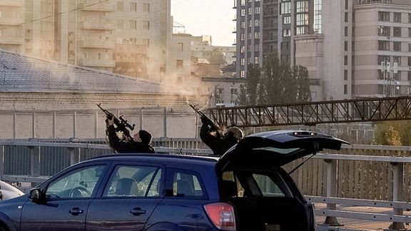 Ukrainian policemen use their assault rifles to fire at drones over Kyiv. October 17, 2022