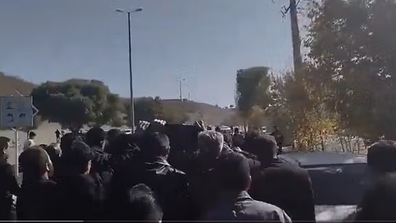 Mourners carry the body of Omid Sarlak during his funeral in Aligoudarz on November 3, 2025.