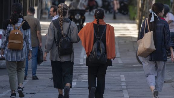 Iranian women walk along an avenue in downtown Tehran without wearing mandatory headscarves, 12 September 2023 (Reuters)