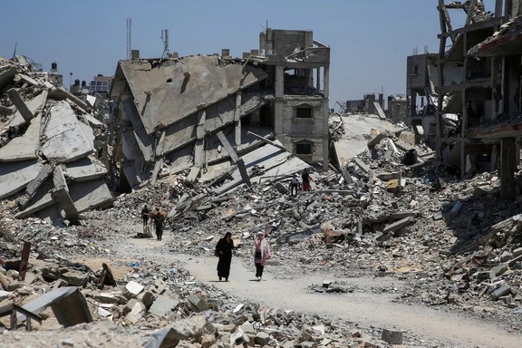 Palestinians walk past the rubble of houses destroyed during the Israeli military offensive in Khan Younis in the southern Gaza Strip July 10, 2024