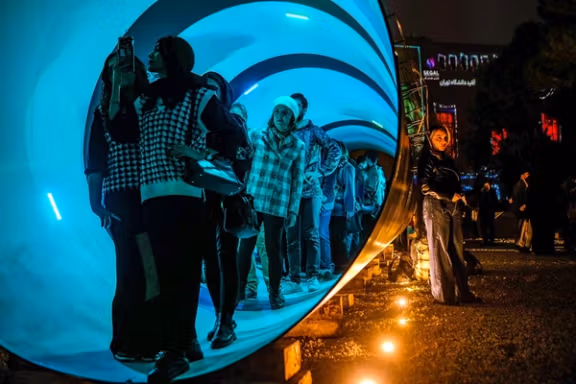 Visitors walk through a tunnel-shaped installation exhibited at the Tehran Design Week, November 15, 2025