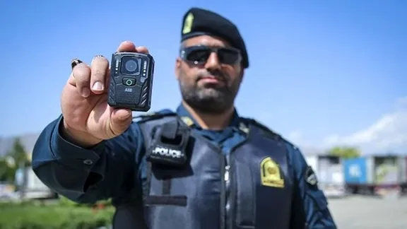 An Iranian special unit officer holds up his body camera (undated)