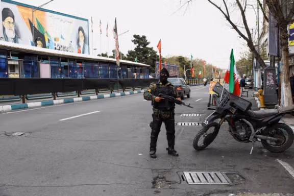 A member of a police force stands guard on a street in Tehran, Iran, March 23, 2026.