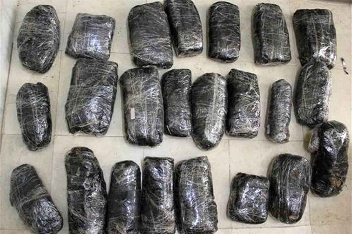 Bundles of opium wrapped in black plastic and tape, likely seized during a drug enforcement operation in Iran.