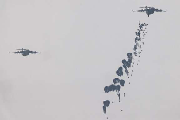 Humanitarian aid falls through the sky towards the Gaza Strip after being dropped from an aircraft, amid the ongoing conflict between Israel and the Palestinian Islamist group Hamas, as seen from Israel, March 29, 2024.