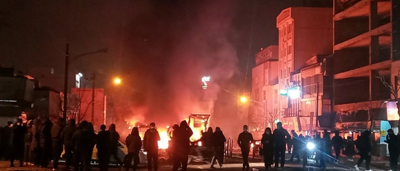 Protesters gather around burning barricades during overnight anti-government demonstrations in Iran.