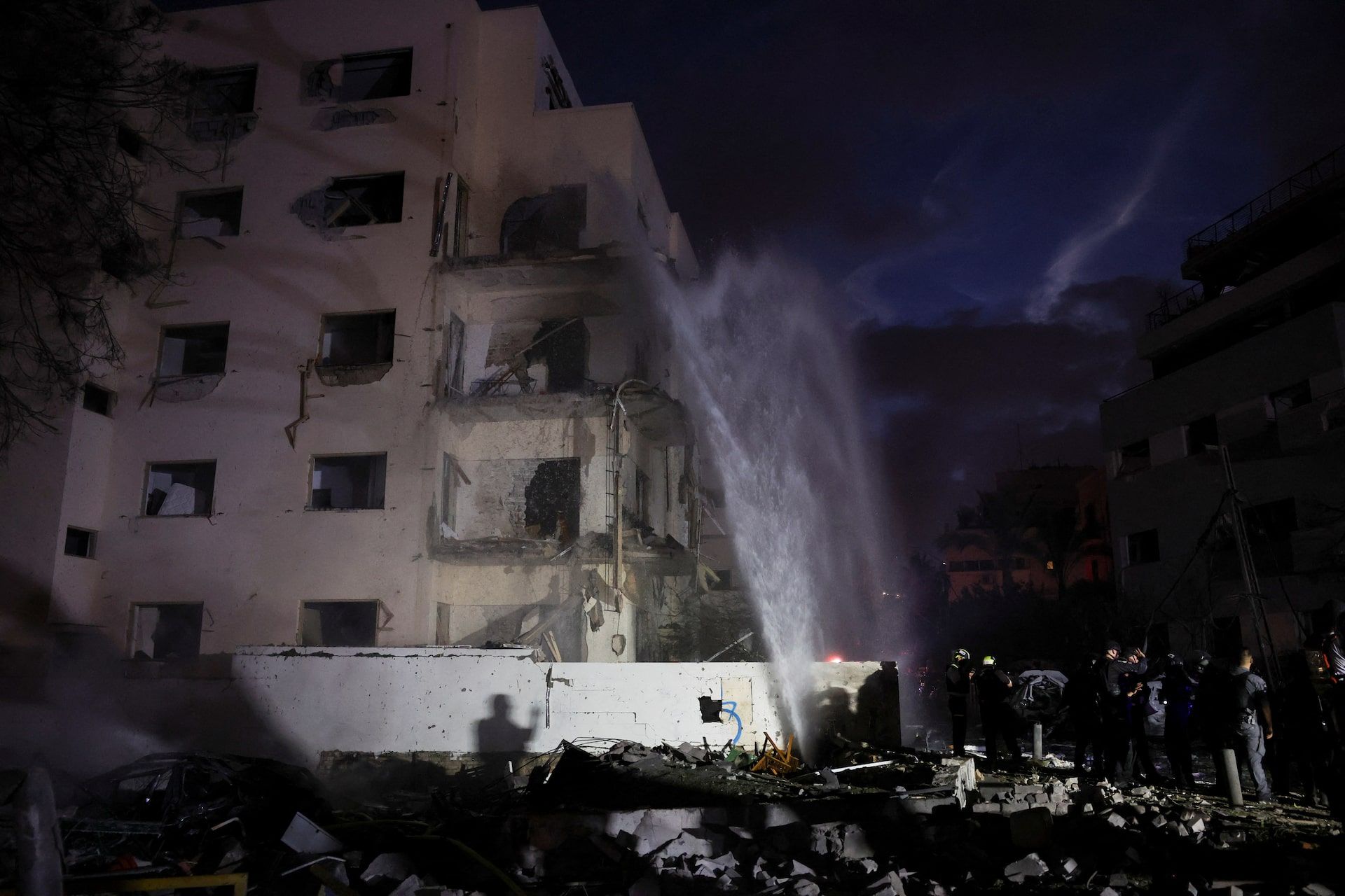 Firefighters and rescue personnel work at an impact site following missile attack from Iran on Israel, in Tel Aviv, June 16, 2025.