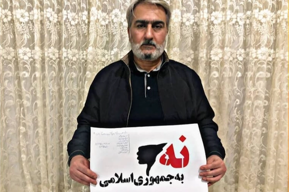Abbas Vahedian Shahroodi, imprisoned Iranian dissident, holding a 'No to Islamic Republic' placard