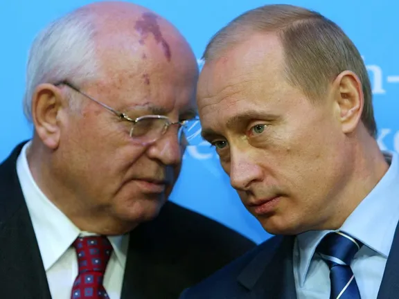 Russian President Vladimir Putin (R) listens to former President of the Soviet Union Mikhail Gorbachev during a news conference following bilateral talks with German Chancellor Gerhard Schroeder at Schloss Gottorf Palace in the northern German town of Schleswig, Germany December 21, 2004