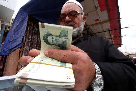 A man buys Iranian rials from a seller of Iranian currency, before the start of the U.S. sanctions on Tehran, in Basra, Iraq November 3, 2018