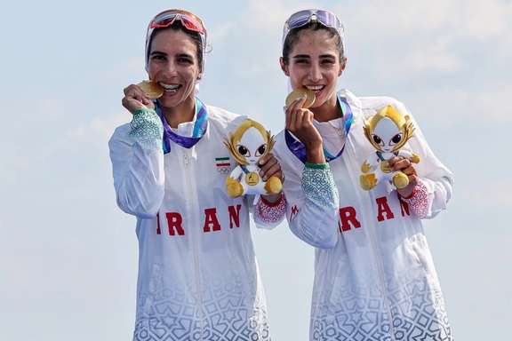 Rowers Kimia Zarei and Zeinab Norouzi celebrate with their gold medals after winning the women’s lightweight double sculls
