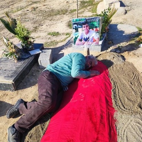 Abulfazl Adinezadeh at his son's grave. Undated