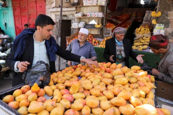 People buy mangoes from a street stall as Yemenis prepare for the fasting month of Ramadan, in Sanaa, Yemen, April 1, 2022.