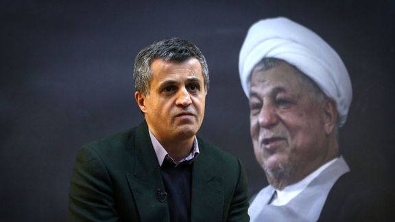 Yasser Hashemi in front of a portrait of his father Ali Akbar Hashemi Rafsanjani