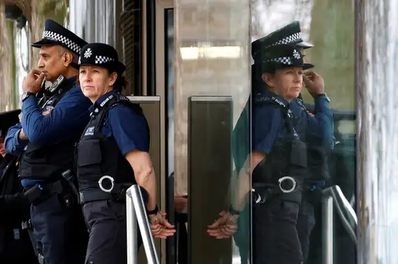 Police officers stand outside New Scotland Yard, the headquarters of the Metropolitan Police, in London, Britain.