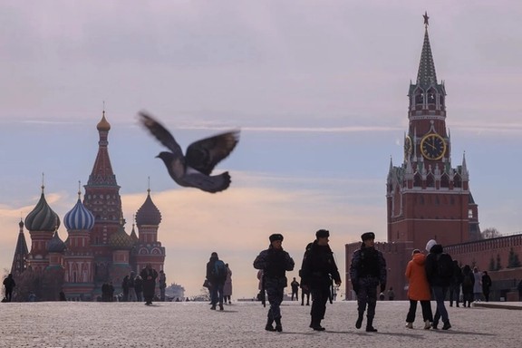 Russian law enforcement officers walk near St. Basil's Cathedral and the Kremlin's Spasskaya Tower on March 20, 2023.
