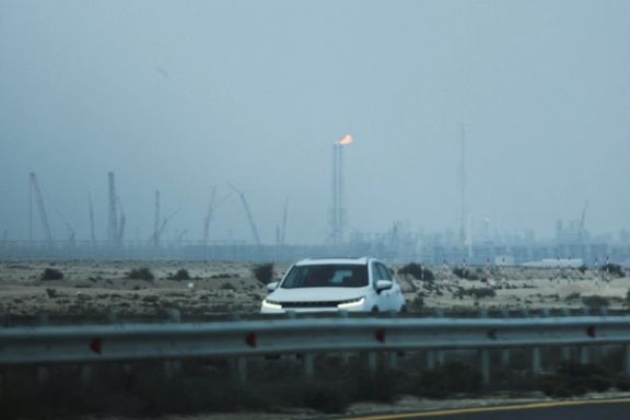 A car passes near QatarEnergy's liquefied natural gas (LNG) production facilities, amid the US-Israeli conflict with Iran, in Ras Laffan Industrial City on March 2, 2026.