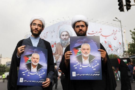 Two clerics hold posters of assassinated Hamas chief, Ismail Haniyeh during his funeral procession, in Tehran, Iran, August 1, 2024.