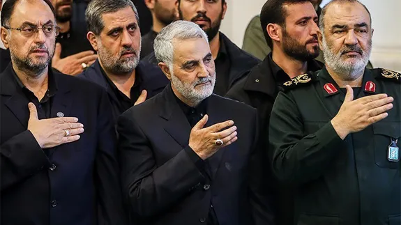 در تصویر، محمدسعید ایزدی پشت سر قاسم سلیمانی دیده میشود