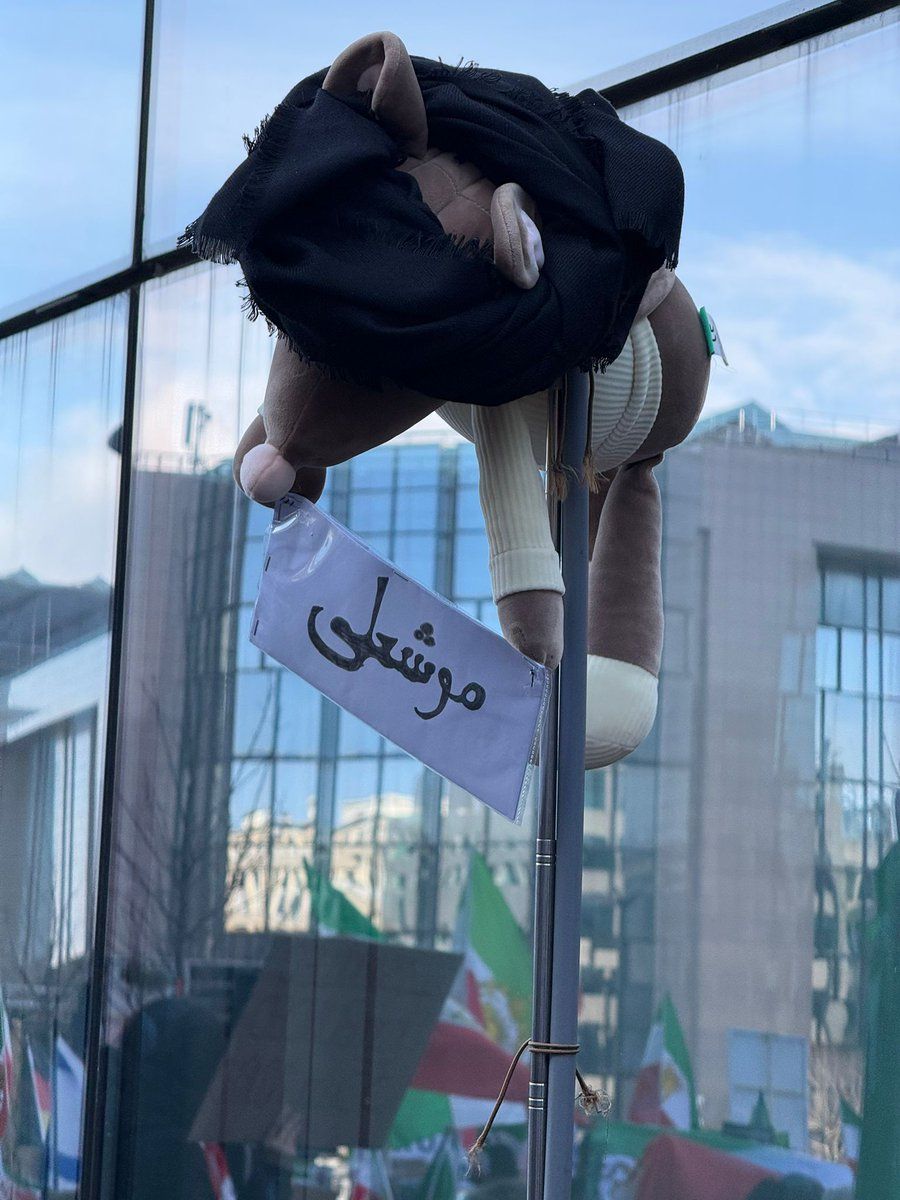 A protester holds a rat doll wearing a turban and bearing the word “Moush-Ali” during a rally in Brussels in support of protests in Iran, January 2026.