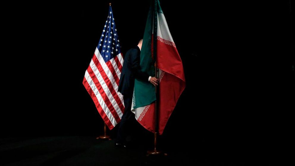 A staffer removing the Iranian flag from the stage after a group picture of officials participating the Iran nuclear talks at Austria International Centre in Vienna, Austria on July 14, 2015