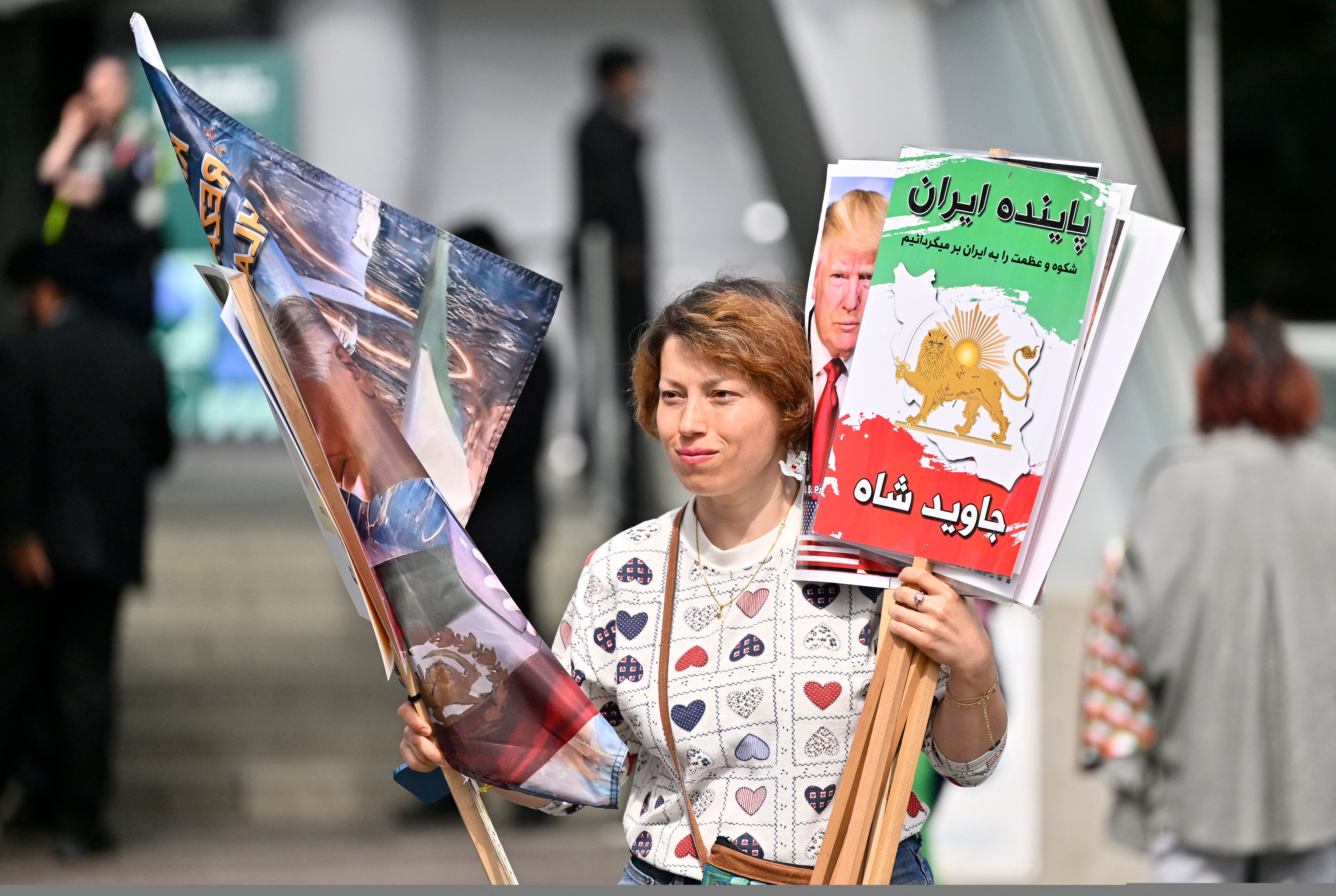 A protester holds demonstration placards outside the Vancouver Convention Centre during the 76th FIFA Congress on April 30, 2026. 