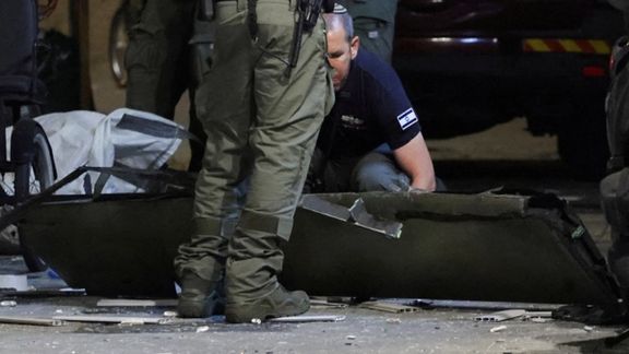 An investigator examines what, according to a police spokesperson, seems to be part of an aerial device, at the site of an explosion, amid the Israel-Hamas conflict in Tel Aviv, Israel July 19, 2024.