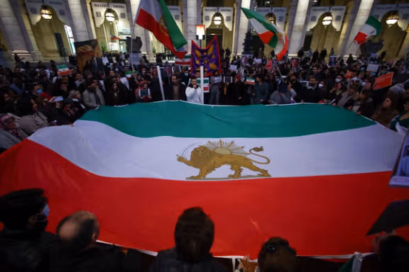 People hold the "Lion and Sun" pre-Iranian Revolution national flag during a rally in support of nationwide protests in Iran, in Rome, Italy, January 13, 2026.