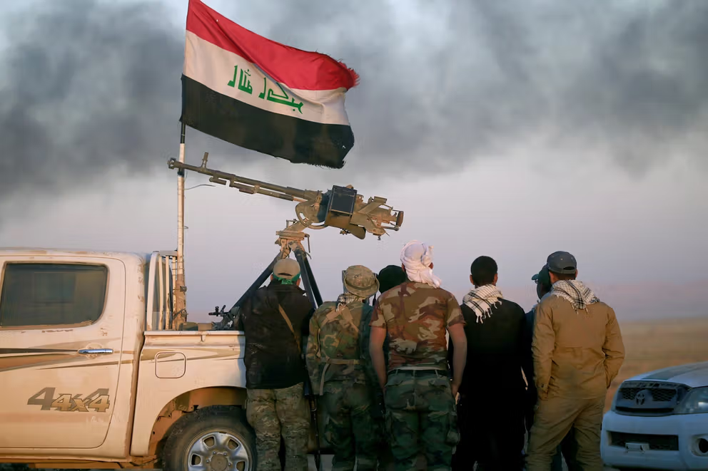 Shi'ite fighters look at smoke rising from clashes during a battle with Islamic State militants at the airport of Tal Afar west of Mosul, Iraq November 18, 2016.
