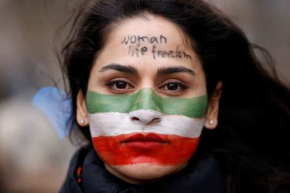 An Iranian woman with "Woman, Life, Freedom" motto written on her forehead in a rally in Brussels in February
