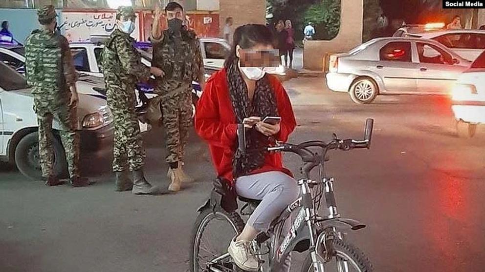 An Iranian woman removing her headscarf in public  