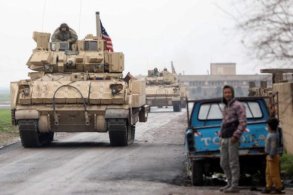 Residents stand on a street during a joint US- Kurdish-led Syrian Democratic Forces (SDF) patrol in the countryside of Qamishli, in northeastern Syria February 8, 2024.